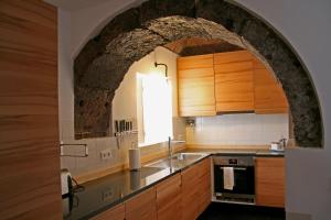 an archway in a kitchen with a sink and a stove at Casa de Almagreira - Empreendimento de Turismo em Espaço Rural - Casa de Campo in Vila do Porto