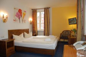 a hotel room with a bed and a desk at Hotel Königin Olga in Ellwangen