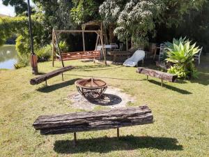 a park with three benches and a swing at SITIO RUSTICO BEIRA RIO in Guararema