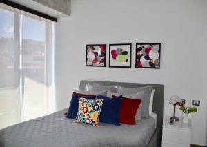 a bedroom with a bed with four pictures on the wall at Cozy Stays Cayala Apartments 2 in Guatemala