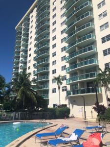 una piscina con tumbonas y un gran edificio en The Blue Island, en Miami Beach