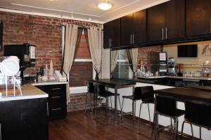 a kitchen with black counter tops and black bar stools at Inn on Folsom in San Francisco