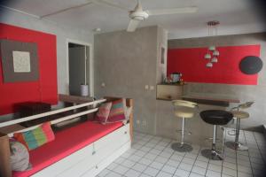 Zimmer mit einem Bett mit einer roten Wand in der Unterkunft Un pied-à-terre au centre de Papeete in Papeete