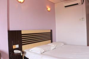1 dormitorio con cama y cabecero en Hotel Lam Seng en Pantai Remis
