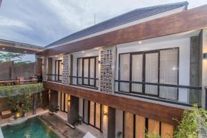 an exterior view of a house with windows and a pool at D Home Seminyak by Pramana Villas in Seminyak