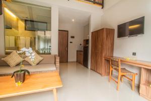 uma sala de estar com um sofá e uma mesa em D Home Seminyak by Pramana Villas em Seminyak