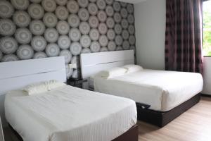 1 dormitorio con 2 camas y una pared con un mural en Hotel Lam Seng en Pantai Remis