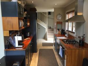 een keuken met houten werkbladen en een klok aan de muur bij Charming Wanaka Cottage in Wanaka