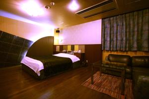 - une chambre avec un lit et un canapé dans l'établissement Hotel Ohirune Racco Higashiosaka ( Adult Only), à Higashiōsaka