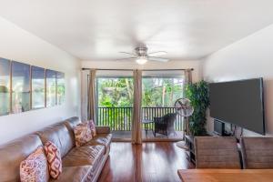 a living room with a couch and a flat screen tv at Lahaina Wonderful Condos in Lahaina