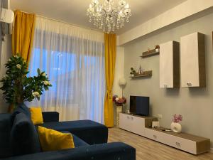 un salon avec un canapé bleu et une télévision dans l'établissement Summerland apartments and Alezzi apartments, à Mamaia