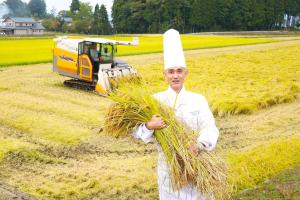 a chef holding a bunch of hay in a field at Hotel Fujita Fukui in Fukui