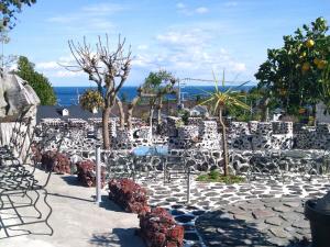 un patio con sedie, alberi e l'oceano di J-Garden a Ito Altre 29 foto