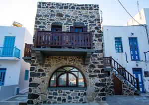 a building with a balcony on the side of it at Plousiadi΄s Stone House in Páloi