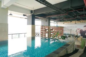 a large pool in a building with blue water at Comfortable and Beautiful 1BR Apartment at Atlanta Residence By Travelio in Pondokcina