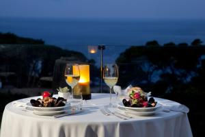 a table with two plates of food and wine glasses at Hotel La Floridiana in Capri