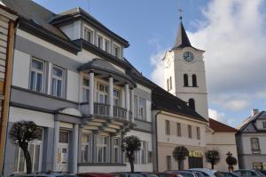 a building with a clock tower and a church at Apartmány vila Týniště in Týniště nad Orlicí