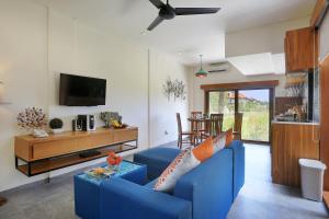 a living room with a blue couch and a tv at The Wina Villa Seminyak in Seminyak