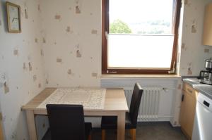 a kitchen with a table and chairs and a window at Ferienwohnung Nüdling in Hilders