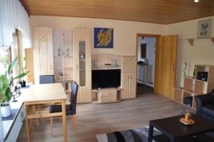 a living room with a television and a dining room at Ferienwohnung Nüdling in Hilders