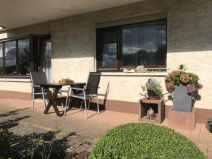 a patio with a table and chairs in front of a building at Ferienwohnung Nüdling in Hilders