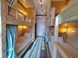 a corridor of a room with bunk beds at 墾丁秋莊會館 附限量停車位 不保證有位置 無法事先預留 背包房無車位 預訂後記得加Line聯繫 in Hengchun