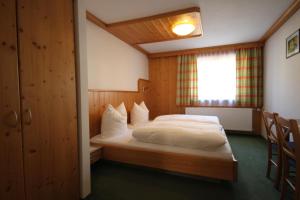 sypialnia z łóżkiem i oknem w obiekcie Pension Aberger w Saalbach Hinterglemm