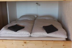 a bed with two pillows sitting on a shelf at Studio tout confort au calme in La Bresse
