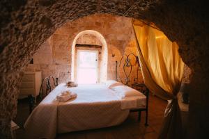 um quarto com uma cama num quarto com uma janela em Trullo Giada em Carovigno