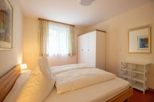 een slaapkamer met een wit bed en een raam bij Ferienwohnung Heidi in Schruns