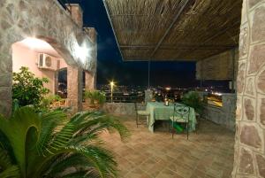 an outdoor patio with a table and chairs at night at Contessa Apartments in Budva