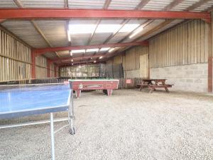 a pool table in a barn with a ping pong table at The Park in Craven Arms