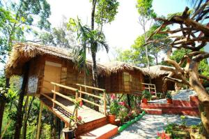 ein kleines Haus mit Strohdach in der Unterkunft Green Trees Munnar in Munnar