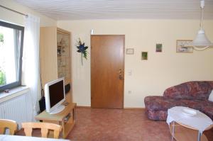 een woonkamer met een bank en een tv bij Haus Barbara in Hilders