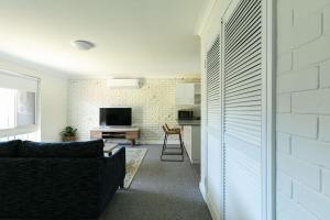 a living room with a couch and a kitchen at Apparition Apartments in Geraldton