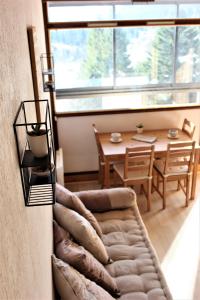 ein Wohnzimmer mit einem Sofa und einem Tisch in der Unterkunft Studio sous les pistes avec vue sur la vallée in La Bresse
