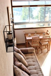 a living room with a couch and a table at Studio sous les pistes avec vue sur la vallée in La Bresse