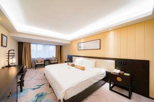 広州市にあるGuangdong Hotel-Free Shuttle & Registration Counter Service during Canton Fairの大きなベッドと机があるホテルの部屋 +37枚の写真