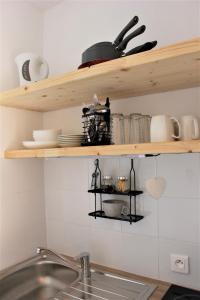 a kitchen with wooden shelves above a sink at Studio sous les pistes avec vue sur la vallée in La Bresse