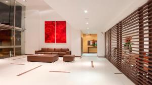 a living room with a couch and a red painting at Hotel Estelar El Cable in Manizales