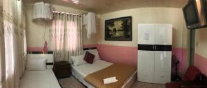 a small bedroom with a bed and a refrigerator at Bich Khue Hotel in Da Lat