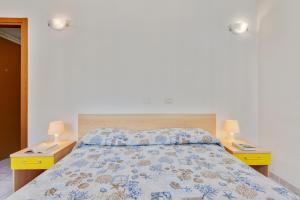 Appartamento Ramerino في بومونته: غرفة نوم مع سرير مع مواقف ليلتين ومصباحين