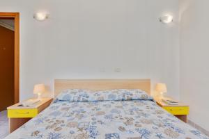 a bedroom with a bed with two night stands and two lamps at Appartamento Ramerino in Pomonte +16 photos