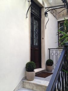 una porta d'ingresso di una casa con due piante in vaso di 74 Crescenzio House a Roma