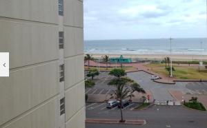a view of a building and a parking lot with the beach at Durban Seashore in Durban