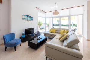 a living room with a couch and a blue chair at Villa Savoya Sunrise by Ezoria Villas in Coral Bay