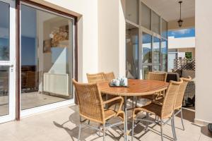 a dining room with a wooden table and chairs at Villa Savoya Sunrise by Ezoria Villas in Coral Bay