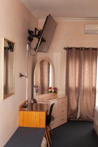 Pokój z biurkiem, umywalką i lustrem w obiekcie Manjimup Motor Inn w mieście Manjimup