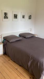 a bed with a brown blanket on a wooden floor at Belle Malouine in Saint Malo