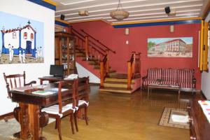 ein Zimmer mit einem Tisch, Stühlen und einer Treppe in der Unterkunft Pousada Villa Parahytinga in São Luiz do Paraitinga